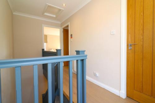 a staircase with a blue railing in a house at Signature - Cross House in Lanark