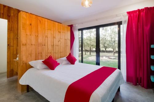 a bedroom with a bed and a large window at Capital O Hacienda Filadelfia, El Atorón, Irapuato in Irapuato