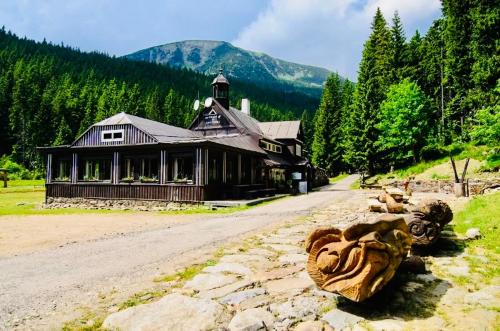 a large building on a dirt road next to a mountain at Horská Bouda v Obřím Dole in Pec pod Snezkou