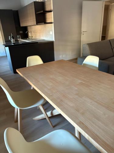 a kitchen with a wooden table and chairs at Vivic Attic Monforte in Monforte dʼAlba