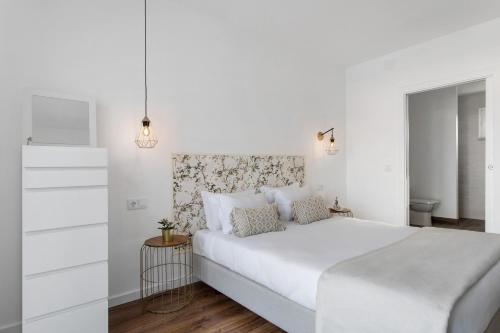 a white bedroom with a white bed and a drawer at Quinta dos Raposos- Nazaré Portugal in Nazaré