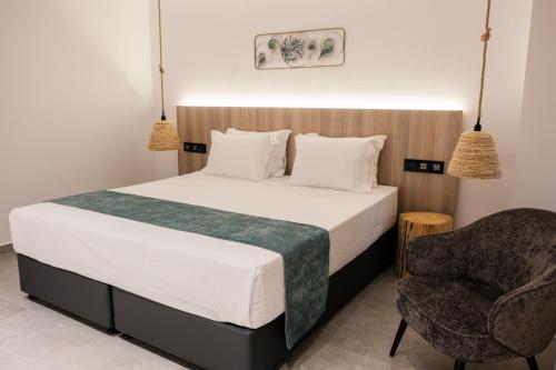 a bedroom with a large bed and a chair at Abacus Suites in Ayia Napa