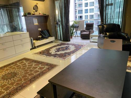 a living room with rugs on the floor and a table at Regalia Hostel Free Infinity Skypool Free in Kuala Lumpur