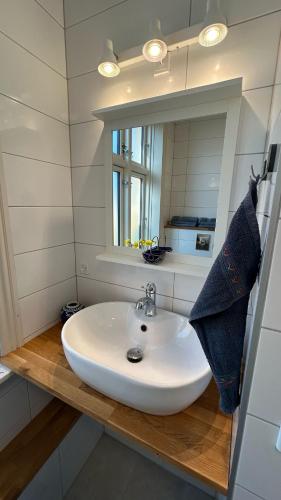 a white sink in a bathroom with a mirror at Apple Blossom Studio - near Rønne and Beach in Rønne