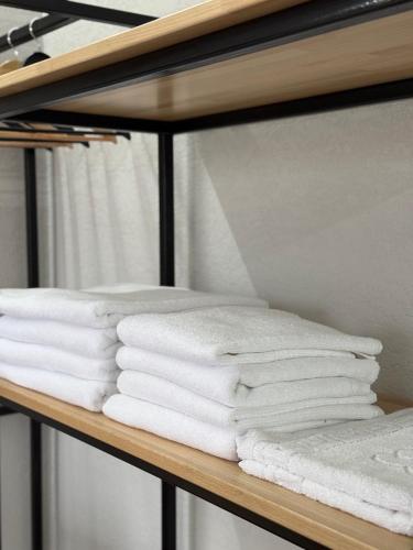 a stack of towels on a shelf in a bathroom at LOFT Hotel Solotvino in Solotvyno