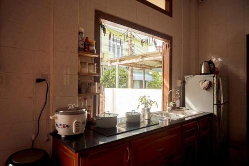 eine Küche mit Theke und Spüle und einem Fenster in der Unterkunft Mit Homestay Phú Quý in Cu Lao Thu
