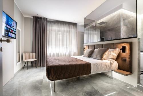 Karma6Rooms - in Sicilia nel centro di Catania في كاتانيا: غرفة نوم بها سرير كبير وتلفزيون