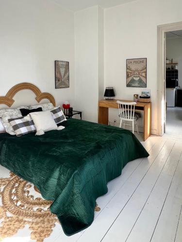 une chambre avec un lit avec une couverture verte dessus dans l'établissement l'appart roubaisien, à Roubaix