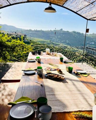 a long wooden table with plates and utensils on it at FLH Douro Casa do Mártir in Vila Marim