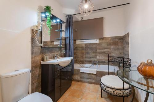une salle de bain avec un lavabo, une baignoire et des toilettes dans l'établissement VILLA JUSTINE VI4239 By Riviera Holiday Homes, à Mandelieu-la-Napoule