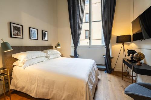 ein Schlafzimmer mit einem großen weißen Bett und einem Fenster in der Unterkunft Maison Luxury Suite - Duomo in Florenz