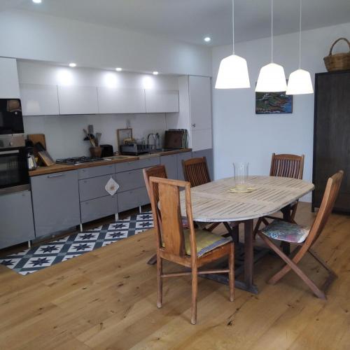 une cuisine avec une table et des chaises dans une pièce dans l'établissement les jardins de la gardiole, à Balaruc-le-Vieux