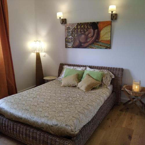 a bed in a room with a painting on the wall at les jardins de la gardiole in Balaruc-le-Vieux