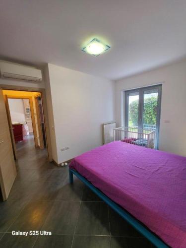 a bedroom with a large bed with a purple blanket at Macrinum - LE DUNE in Silvi Marina
