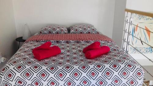 - un lit avec 2 oreillers rouges dans l'établissement Duplex cosy atypique à la plage - hyper centre, au Havre