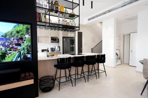 a kitchen with a bar with black stools at VILA ME in Eilat