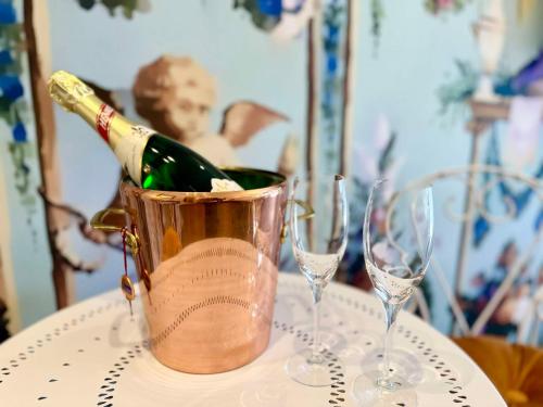 a bottle of champagne in a bucket on a table with glasses at Sissis Paradies Appartement mit Balkon & Flussblick- Das Alpenzeit im Zentrum mit Parkplatz in Bad Aussee