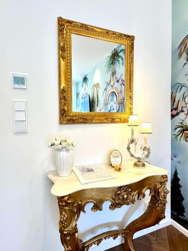 an ornate console table with a mirror on a wall at Sissis Paradies Appartement mit Balkon & Flussblick- Das Alpenzeit im Zentrum mit Parkplatz in Bad Aussee