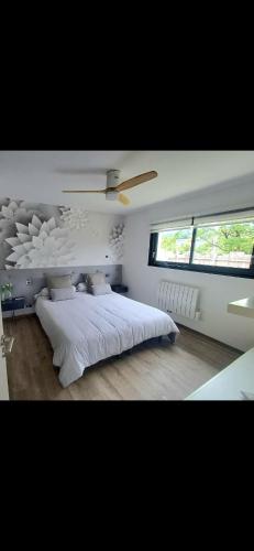 une chambre avec un grand lit blanc et une fenêtre dans l'établissement Maison cosy, à Grésy-sur-Aix