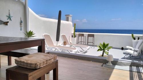 un balcon avec des chaises blanches et une vue sur l'océan dans l'établissement Ático Los Balcones, à Santa Cruz de la Palma
