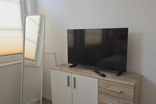 a flat screen tv sitting on top of a cabinet at Westwind - schöne neue 2-Zi Whg 37qm für 1-4 Pers in Juist