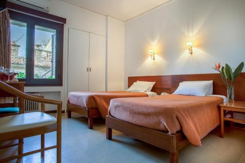 a bedroom with two beds and a window at Nefeli Hotel in Athens
