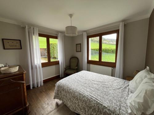 une chambre avec un lit et deux fenêtres dans l'établissement Lac d'Annecy, entre lac et montagne, à Menthon-Saint-Bernard