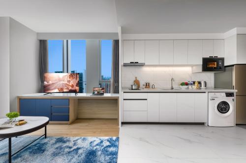 a kitchen with white cabinets and a dishwasher at Citadines Guanghua Chengdu in Chengdu