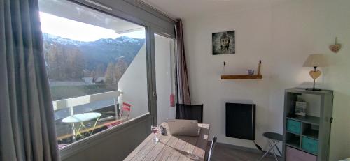 une pièce avec une grande fenêtre avec vue sur une montagne dans l'établissement Studio 4 personnes Vars les Claux 100m des pistes, à Vars