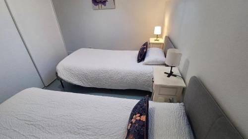 a small room with two beds and a desk at La Bonnerie-Le Pupitre La Bouëxière in La Bouexière