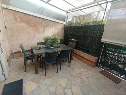 une terrasse avec une table et des chaises dans une serre. dans l'établissement Appartement traquille, à Toulon