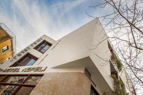 a white building with a sign on the side of it at Nefeli Hotel in Athens