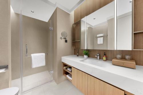 a bathroom with a sink and a shower at Citadines Guanghua Chengdu in Chengdu