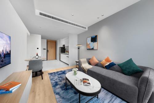 a living room with a couch and a table at Citadines Guanghua Chengdu in Chengdu