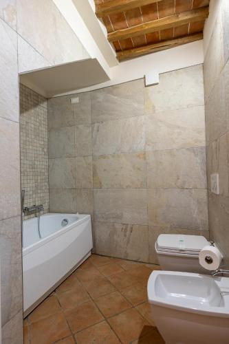 a bathroom with a tub and a toilet and a sink at Tenuta Tegolato in Barberino di Val dʼElsa