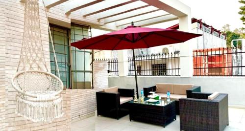 a patio with a red umbrella and a table and chairs at Grand Berkshire Signature Hotel operated by Berkshire Hotels & Resorts UK in Islamabad