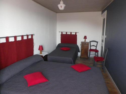 1 dormitorio con 2 camas y almohadas rojas en Gite de Carboniès en Saint-Félix-de-Lunel