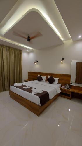a bedroom with a large bed and a television at Aarvis House in Mahabaleshwar