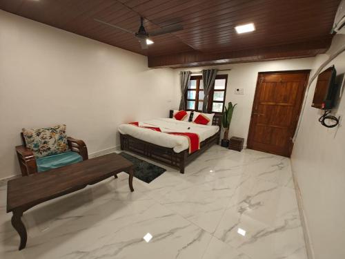 a bedroom with a bed and a bench in a room at The Mango Valley Nature's Stay in Alibag