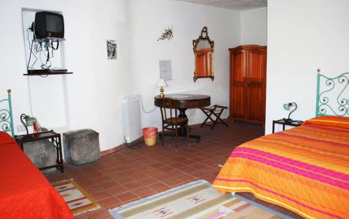 a bedroom with a bed and a desk in a room at Case Zuccaro in Trecastagni