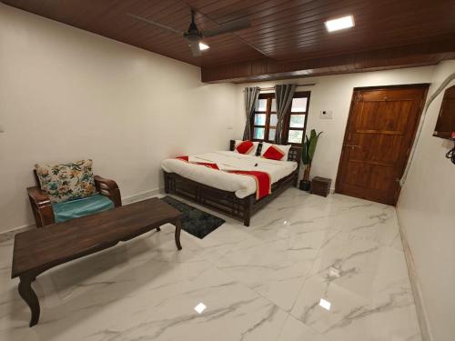 a bedroom with a bed and a bench in a room at The Mango Valley Nature's Stay in Alibag