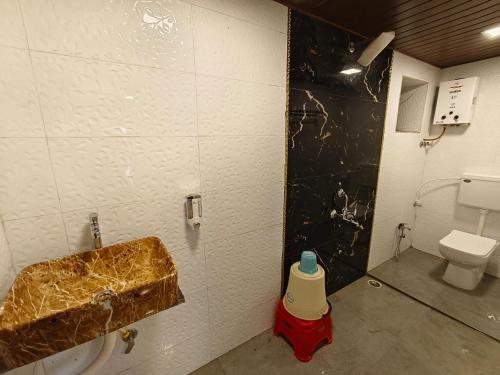 a bathroom with a sink and a toilet at The Mango Valley Nature's Stay in Alibag