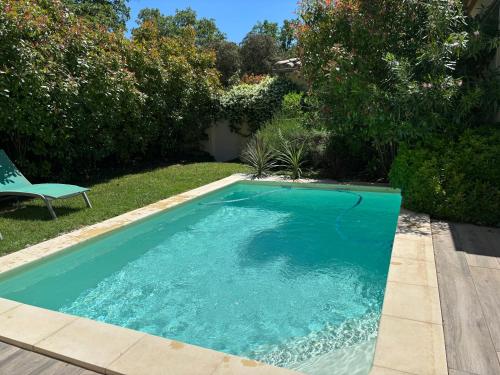 - une piscine dans une cour avec une chaise dans l'établissement Les Jardins du Castelas - Domaine et Spas, à Uchaux