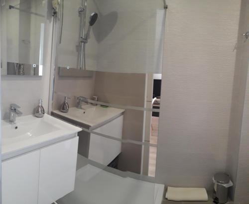 une salle de bain blanche avec deux lavabos et une douche dans l'établissement Stella Maris, à Cagnes-sur-Mer