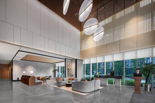 a lobby with couches and chairs in a building at Citadines Guanghua Chengdu in Chengdu