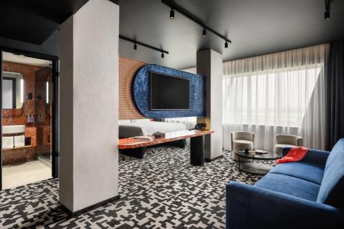 a hotel room with a couch and a tv at TRIBE Budapest Airport in Budapest
