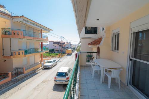 a balcony with a table and a car on a street at Minty Home by RentalsPro - Nea Flogita Halkidiki in Flogita
