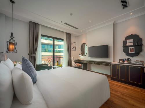 a bedroom with a large white bed and a television at 22 Land Hotel in Hanoi