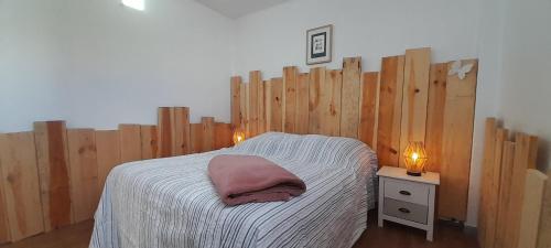 a bedroom with a bed with a wooden wall at Famara - Casa Marosenia in Güime