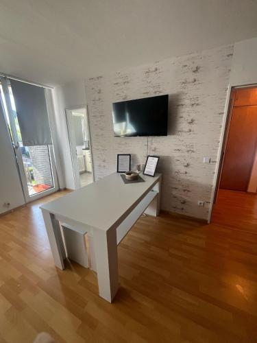 a white table in a room with a tv on a wall at Wohnglück 2 in Herten